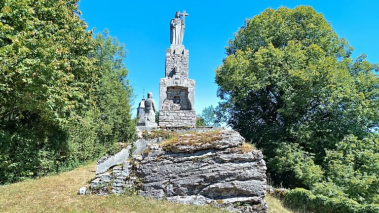 Monument du Christ-Roi au belvédère de Passavant avec le clocher de l’église Saint-Antide en arrière-plan