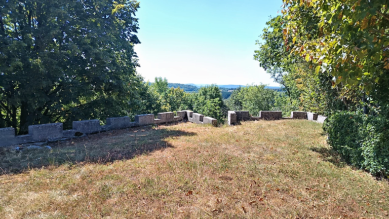 Espace du belvédère de Passavant bordé d’un muret crénelé face aux collines boisées