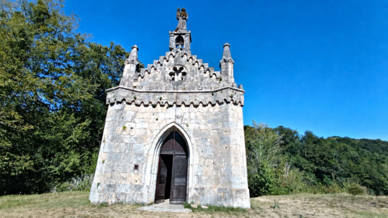 Vue de face de la chapelle Saint-Ermenfroi en pierre au-dessus du Val de Cusance