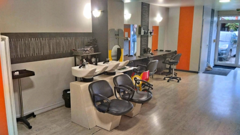 Fauteuils de coiffure et bacs à shampoing, avec l’entrée du salon Emm’Style en arrière-plan