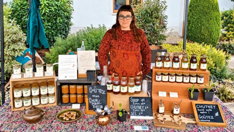 Nina sur son stand de marché avec les produits artisanaux de La Petite Glaneuse.