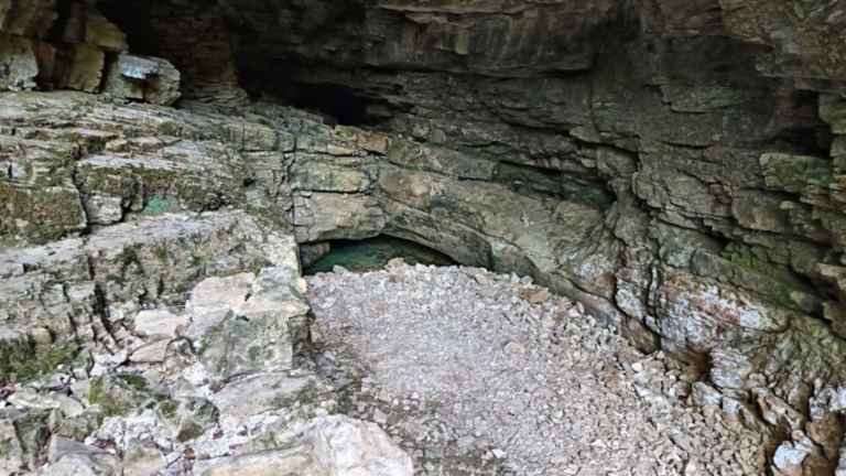Vue d’ensemble du porche et des éboulis calcaires de la Source Verte à Cusance