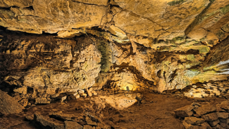 Grande salle rocheuse éclairée au début du parcours des Grottes de Bèze